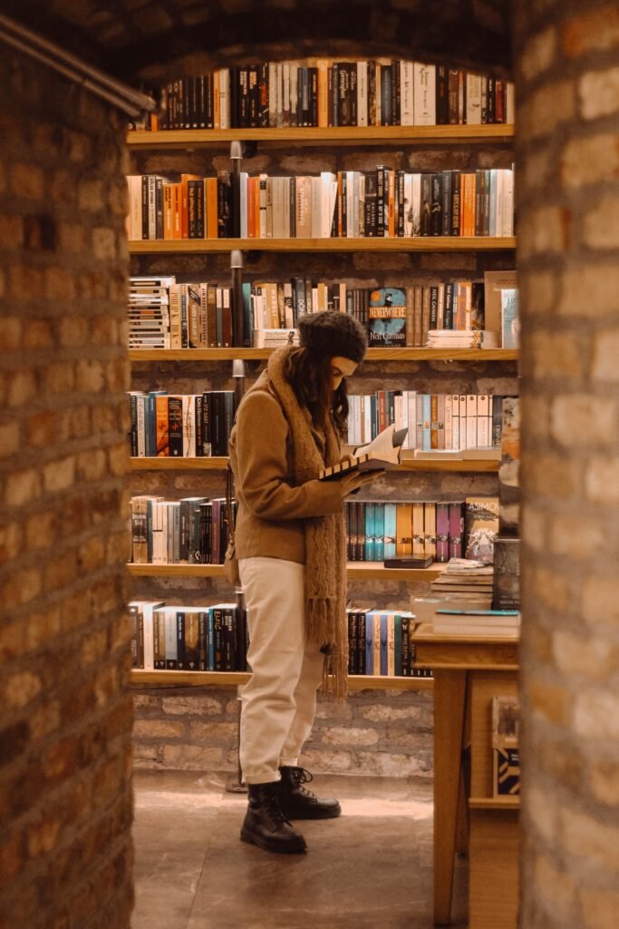 Woman reading a book in a cosy bookshop – Stems From The Gut fibromyalgia book
