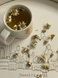 Cup of chamomile tea with chamomile flowers